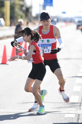 下野7区の父・山口大喜(奥)から8区の娘・明里にたすきをつなぐ=壬生町、鈴木航撮影