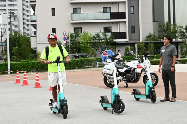 電動キックボードを試乗する市民＝29日午後、宇都宮市宮みらい