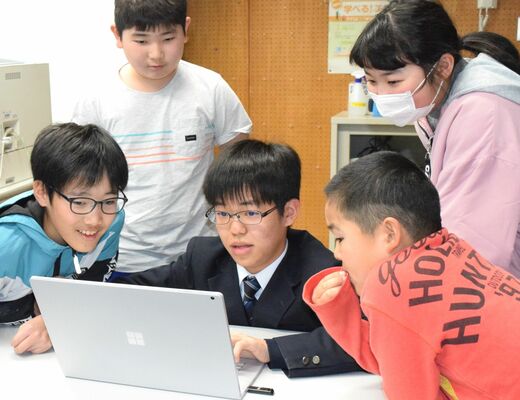 特別支援学級の児童にプログラミングの楽しさを教えた神山さん（中央）