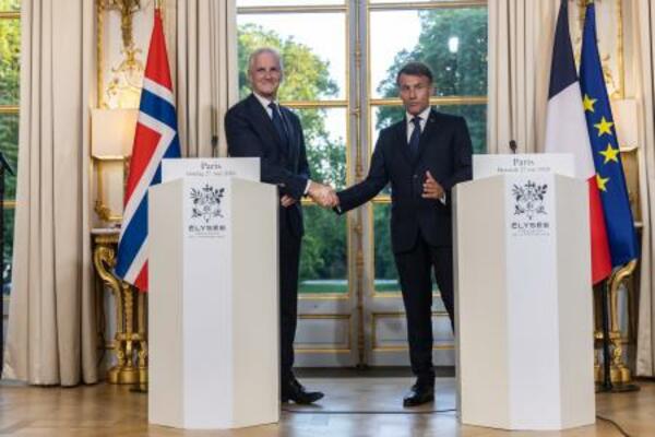 27日、パリのエリゼ宮で握手するフランスのマクロン大統領(右)とノルウェーのストーレ首相(Christophe Petit Tesson提供、AP=共同)