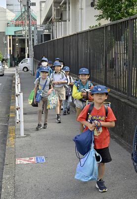 授業が再開し、オリオン通り周辺を歩いて登校する児童たち=11日午前7時50分、宇都宮市中央本町、広瀬華撮影