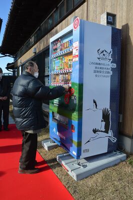 支援自販機で飲み物を買い求める市民