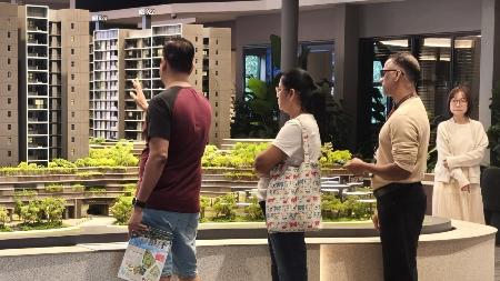 　新築コンドミニアムのショールームで建物の模型を見つめる客＝３月２８日