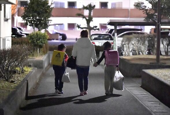 親子を支援する居場所から自宅へ帰る歩美ちゃん（右）。母（中央）と手をつなぎ笑顔で話す姿が見られた＝９日夜、宇都宮市内