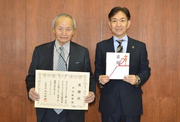 市に１００万円を寄付した半田さん（左）と早川市長