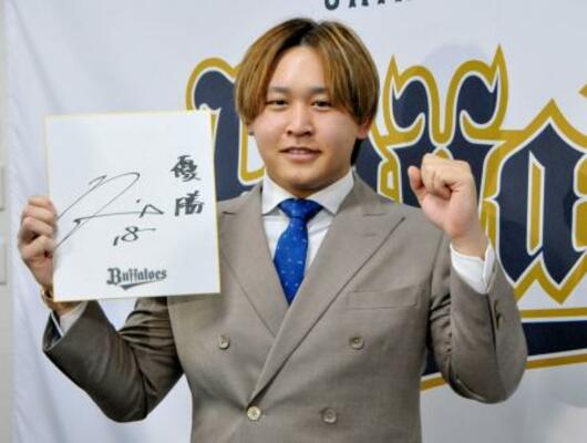 契約更改を終え、来季の目標を書いた色紙を手にポーズをとるオリックスの宮城=18日、大阪市