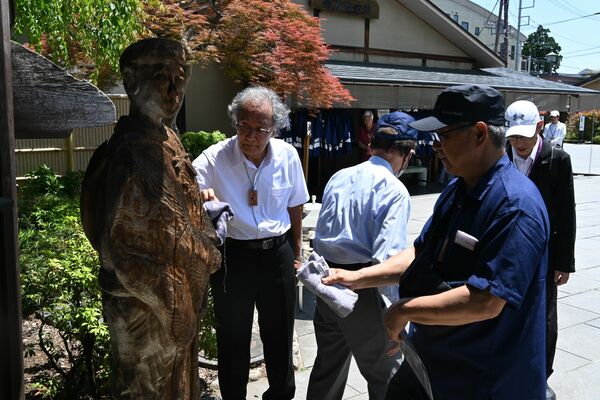 芭蕉像をタオルで「お身ぬぐい」する参加者
