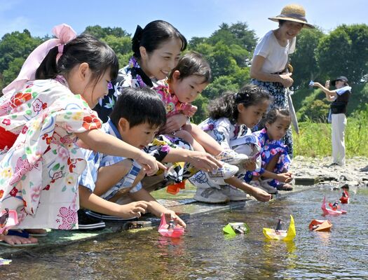 下野人形を乗せた小舟を流す子どもたち＝７日午前11時10分、小山市小山