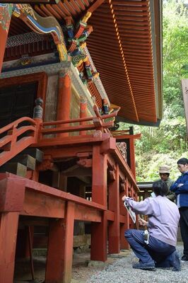 市職員による説明を聞きながら樺崎八幡宮を見学する来場者