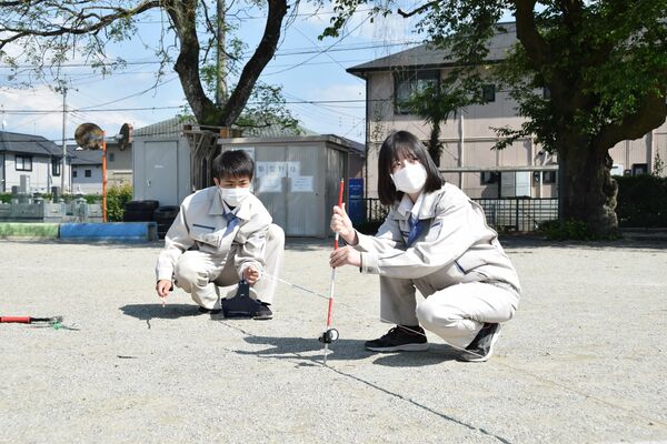 メジャーを使って距離を測る生徒