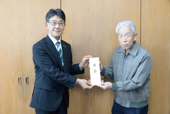 大関町長に目録を手渡す吉田さん（右）