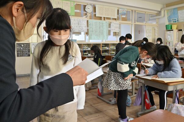 担任と通知表を見ながら２学期を振り返る児童＝２３日午前９時４５分、那須烏山市愛宕台