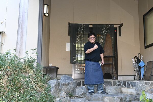 石段を上がった所にある入り口と店長の仲島さん