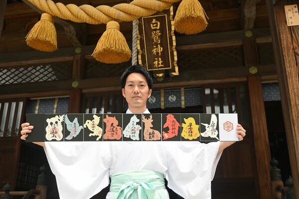 「型抜き御朱印」を手にする上野禰宜