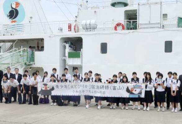 「えとぴりか」(後方)に乗船宿泊して、北方領土問題を学ぶ研修に参加する富山県の中学生ら=4日午後、射水市