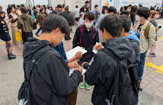 　市民団体「日本平和委員会」が実施した、憲法に関するアンケートに答える若者たち＝３日午後、東京・渋谷