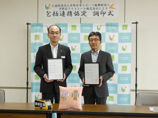 協定書を手にする高井社長（左）と青木理事長