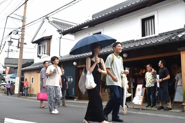ビールを片手に嘉右衛門町を歩く来場者