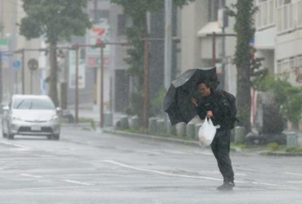　台風６号の影響で風雨が強まる鹿児島市内を歩く男性。３日にかけて西日本から東日本の太平洋側に近づく恐れがある＝２日午前