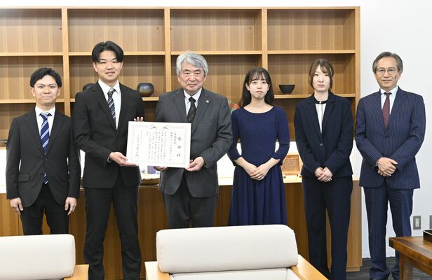 浅野市長（左から３人目）から感謝状を手渡された白鴎大の学生、卒業生と下村特任教授（右）