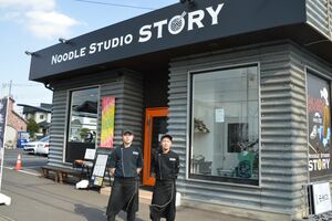 店舗の前に立つ店長の松本さん（左）