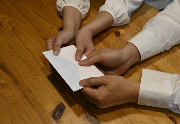女子生徒が残した手紙を手にする両親。そのメッセージを伝えたいと願っている＝４月下旬、県央地区