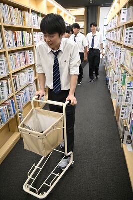 図書館カートで移動しながら改良点を探す高校生たち