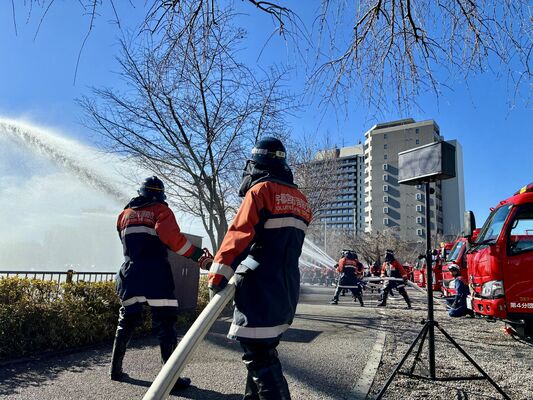 一斉放水する消防団員たち