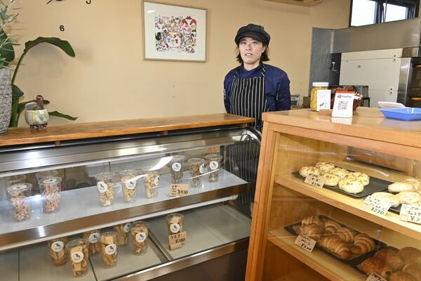 約20種類のパンが並ぶ店頭と店長の鈴木さん
