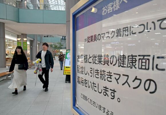 従業員のマスク着用継続を知らせる案内板。わずかながらマスクを外した来店客の姿もあった＝13日午後、宇都宮市インターパーク６丁目