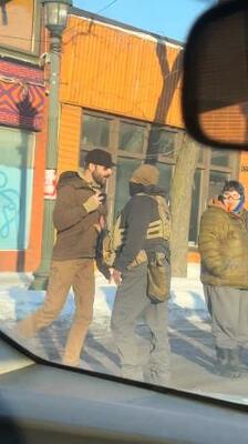 捜査当局者の近くで後ずさりするアレックス・プレッティさん(左)=24日、米ミネアポリス(ロイター=共同)