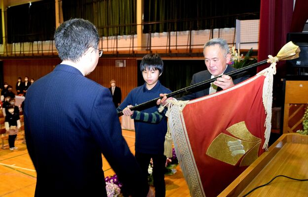 校旗を返納する増渕校長（右）