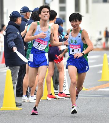 本県の２区若田（左）が３区海老澤にたすきをつなぐ＝広島市内