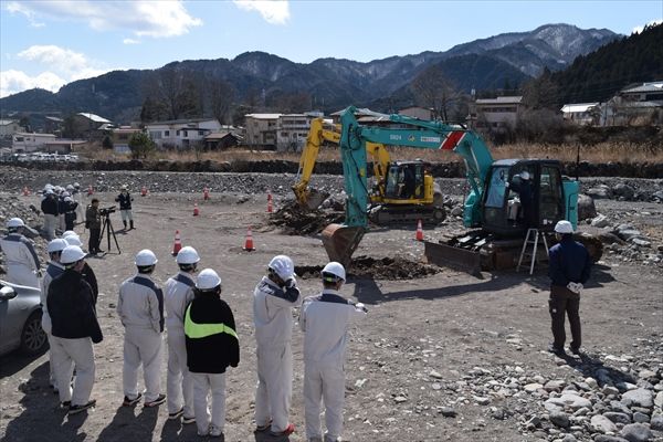 大谷川砂防工事の現場で指導を受けながら建設機械を操作する今市工業高の生徒たち