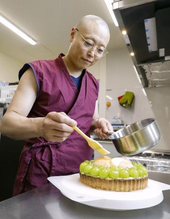 　タルトの仕上げをする住職の阿部真典さん＝北海道当麻町