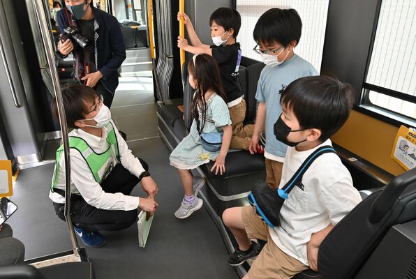 市職員（左）からＬＲＴの説明を聞く子どもたち
