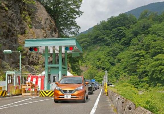 全線開通した「白山白川郷ホワイトロード」の料金所を通る車=12日午前、石川県白山市