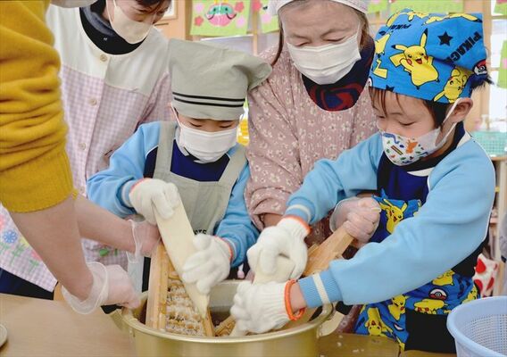 鬼おろしでダイコンをする園児たち