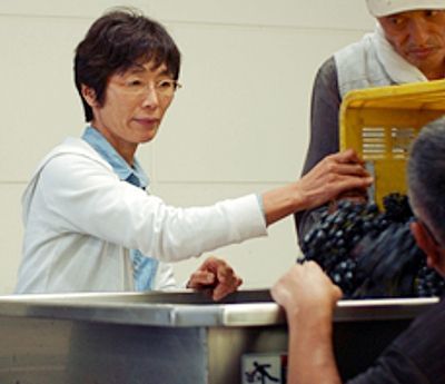 ブドウの仕込み作業をする園生たちを見守る越知さん
