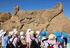砂の彫刻展、恐竜の巨像が並ぶ