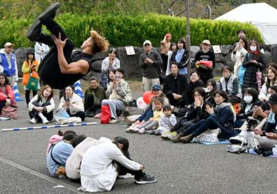 「大道芸ワールドカップin静岡2025」で、座った子どもたちの上を宙返りで飛び越えるアーティスト=31日午後、静岡市
