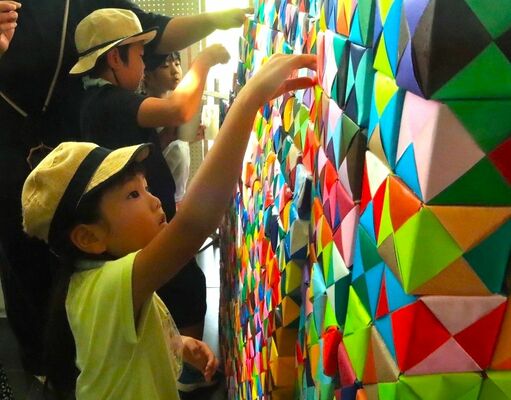 折り紙の立方体を重ね、「ＯＲＩＧＡＭＩのいえ」を作る子どもたち＝上三川町提供