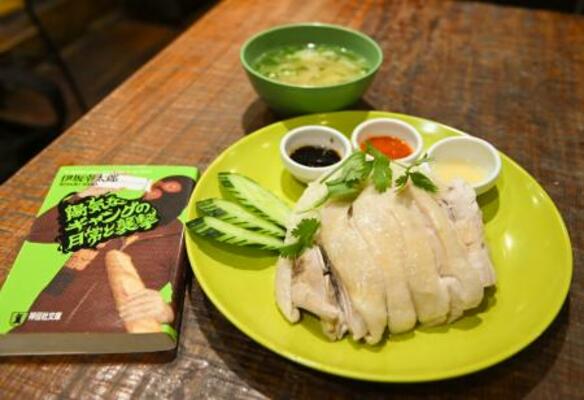 　「夢飯」の人気メニュー、チキンライス（右）と、「にわとり文庫」で購入した伊坂幸太郎さん著「陽気なギャングの日常と襲撃」の文庫本＝東京都杉並区