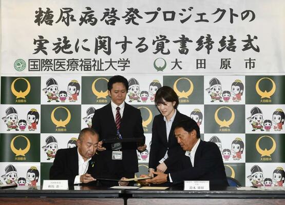 覚書に署名をする相馬市長(前列左)と国際医療福祉大の鈴木学長(同右)