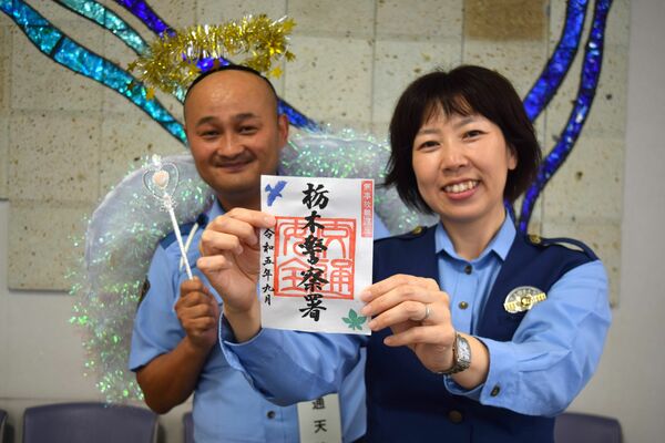 「御署印」を持つ菅野巡査部長（右）と交通天使（左）