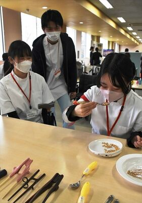 利き腕などが利かないことを疑似体験し「自助具」を試す参加者