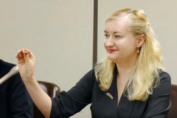 　外国法事務弁護士のバッジを手にするイリーナ・ウリバチョバさん＝２０２５年１０月、東京・霞が関の司法記者クラブ