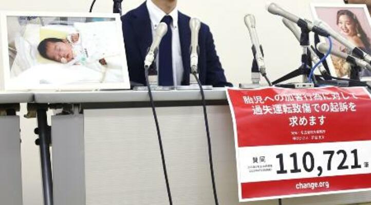 昨年9月、初公判後に妻沙也香さん(右)、長女日七未ちゃん(左)の写真を掲げ記者会見する研谷友太さん=愛知県一宮市