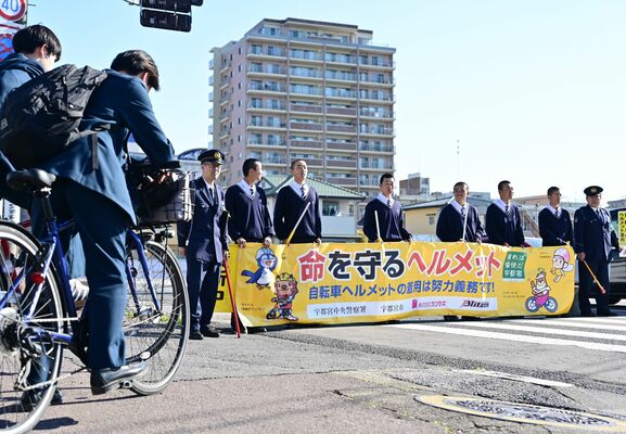 高校生が自転車のヘルメット着用などを呼びかけた街頭啓発＝８日午前８時、宇都宮市桜５丁目