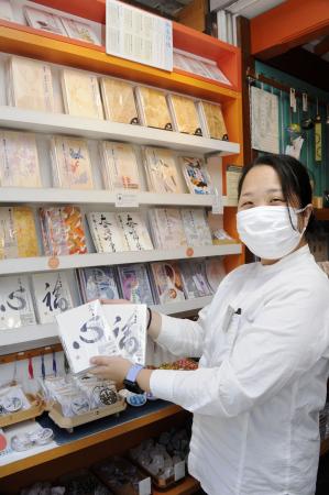 売れ筋の御朱印帳を手にする丹下めぐみさん=東京都台東区
